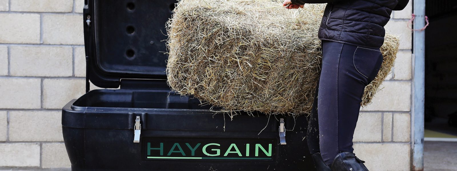 Frau befüllt HG 2000 mit ganzem Heuballen