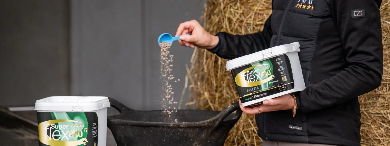 Reiterin gibt NAF Superflex PRO Omega zu Kraftfutterration